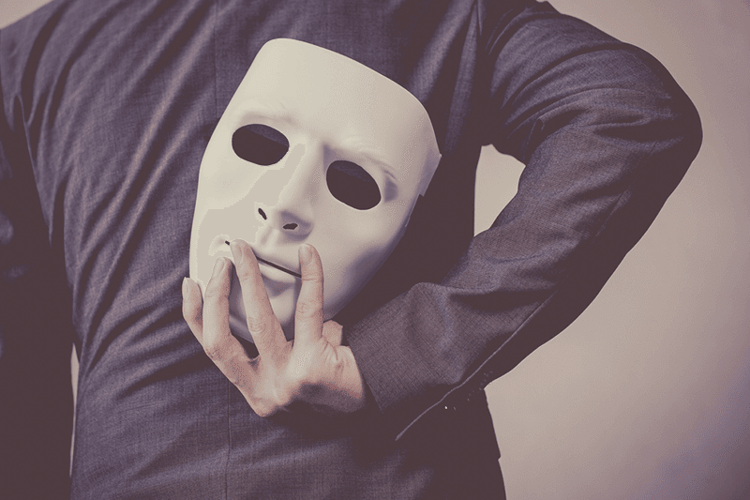 Man-holding-a-mask-behind-his-back