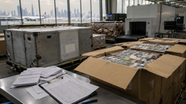 Air cargo containers and customs inspection documents at a Dubai freight terminal