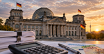 German Bundestag building with tax documents, a calculator, and euro banknotes in the foreground.