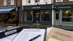 British high street with a vape shop storefront and tax enforcement documents
