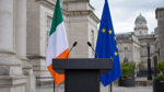 Conceptual government briefing lectern with Irish and European Union flags.
