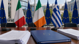 Irish, Italian, Greek, and European Union flags outside a government building beside regulatory documents.