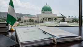 Nigerian flag beside legislative documents representing the dispute over a tobacco control amendment bill.
