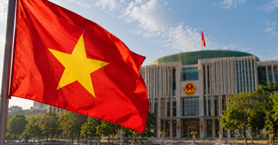 Vietnamese national flag waving in front of a government building in Hanoi, illustrating proposed tobacco sales restrictions and tougher vaping laws.